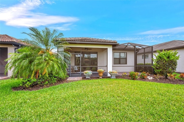 back of house featuring a yard, ceiling fan, and a lanai