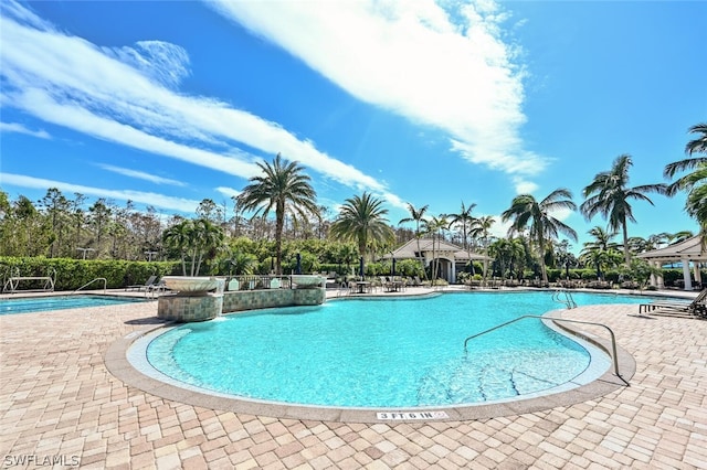 view of swimming pool featuring a patio and pool water feature