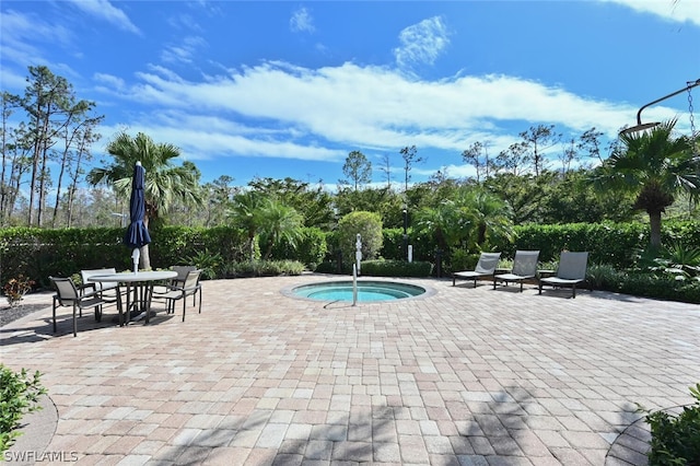 view of swimming pool featuring an in ground hot tub and a patio area