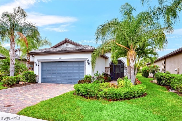 ranch-style home featuring a tiled roof, an attached garage, decorative driveway, a front lawn, and stucco siding