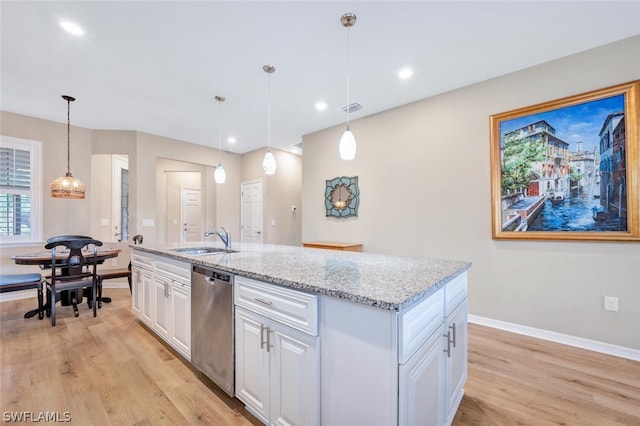 kitchen featuring dishwasher, a center island with sink, light hardwood / wood-style floors, and pendant lighting