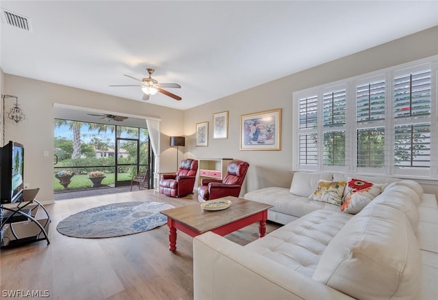 living room with a wealth of natural light, ceiling fan, and hardwood / wood-style floors