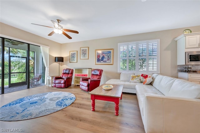 living room with ceiling fan and hardwood / wood-style flooring