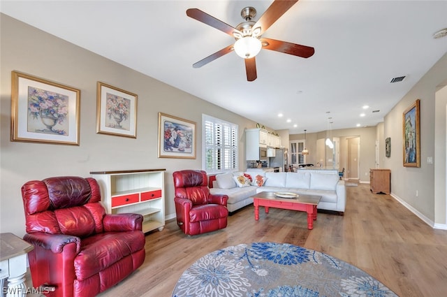 living room with ceiling fan and light wood-type flooring