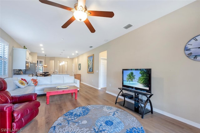 living room featuring ceiling fan and light hardwood / wood-style flooring