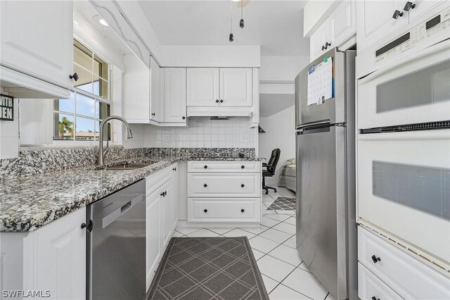 kitchen with sink, white cabinetry, stainless steel appliances, and backsplash