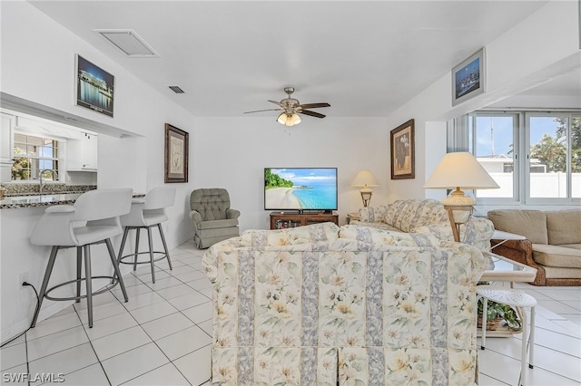 tiled living room with ceiling fan