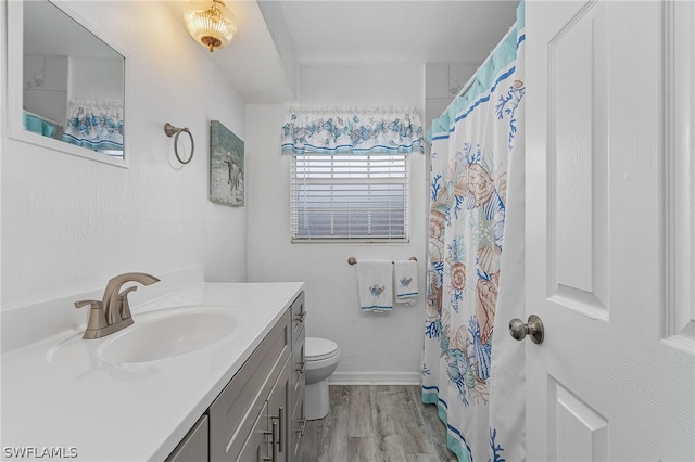 bathroom with wood-type flooring, toilet, and vanity