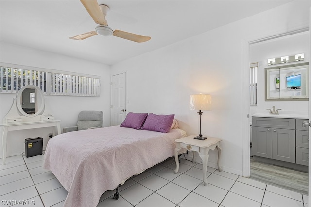 bedroom featuring sink, ensuite bathroom, light wood-type flooring, and ceiling fan