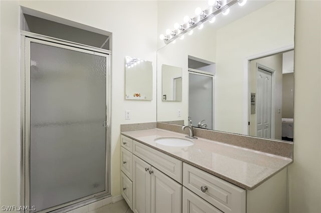 bathroom featuring a shower with door and vanity