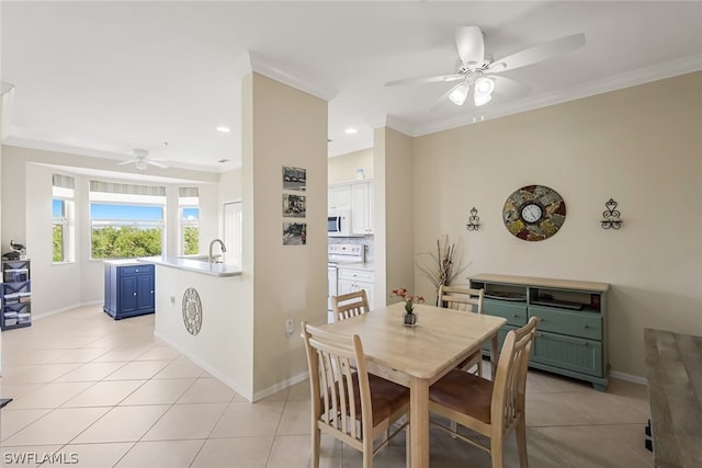 dining area featuring crown molding, sink, light tile patterned floors, and ceiling fan