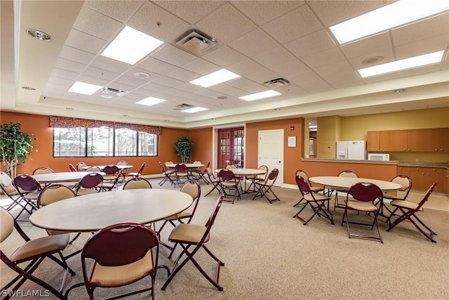 carpeted dining room with a paneled ceiling