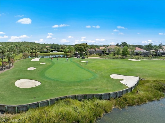 view of property's community featuring a water view, a yard, and golf course view