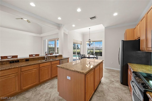 kitchen with stainless steel appliances, a kitchen island, a sink, visible vents, and dark stone counters