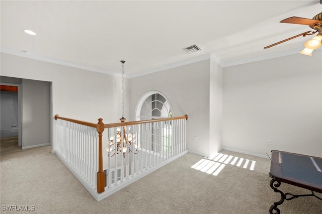 hall with a chandelier, light carpet, visible vents, baseboards, and ornamental molding