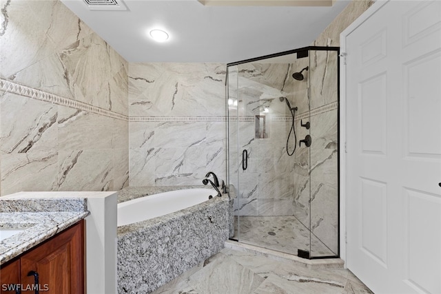 bathroom with tile patterned flooring, tile walls, separate shower and tub, and vanity