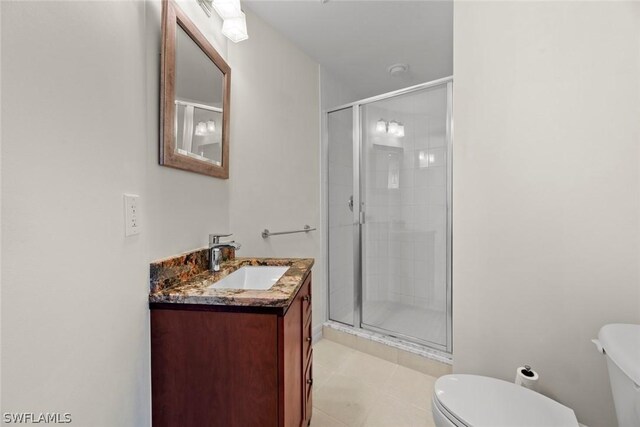 bathroom featuring tile patterned floors, toilet, an enclosed shower, and vanity