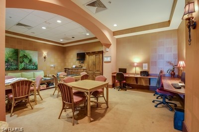 dining room featuring a paneled ceiling, a raised ceiling, and light carpet