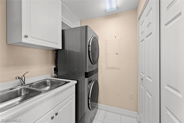 laundry room with stacked washer and clothes dryer, sink, cabinets, electric panel, and light tile patterned floors