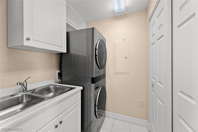 laundry area featuring electric panel, light tile patterned flooring, a sink, stacked washer and clothes dryer, and cabinet space