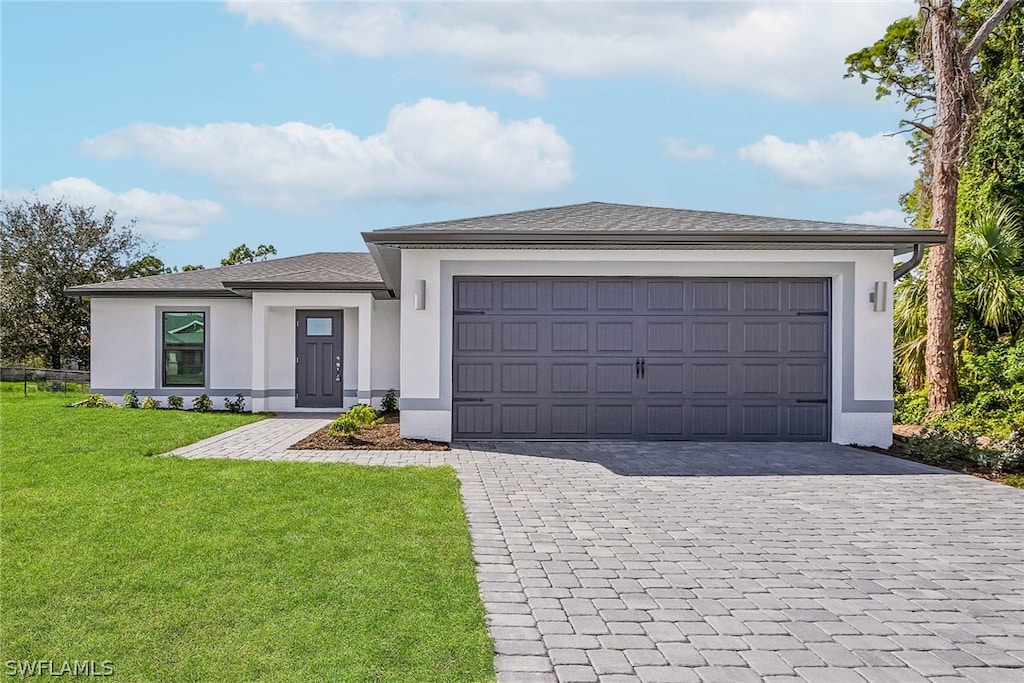 view of front of property with a front yard and a garage