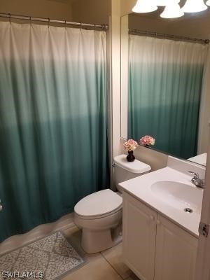 bathroom featuring vanity with extensive cabinet space, toilet, and tile flooring