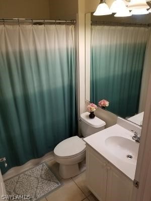 bathroom with toilet, tile flooring, and vanity