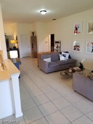 tiled living room featuring sink