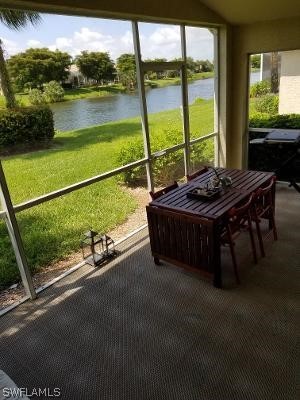 sunroom featuring a water view