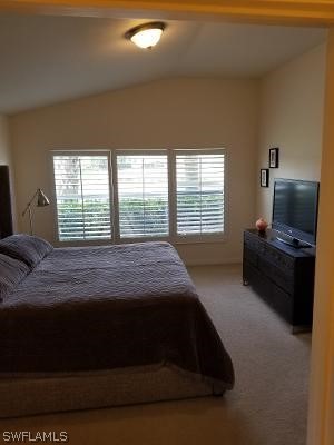 carpeted bedroom with vaulted ceiling