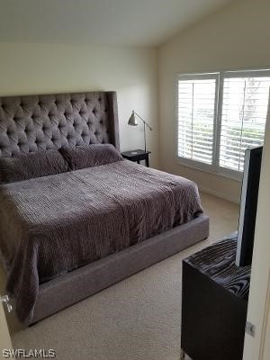 bedroom featuring vaulted ceiling and carpet