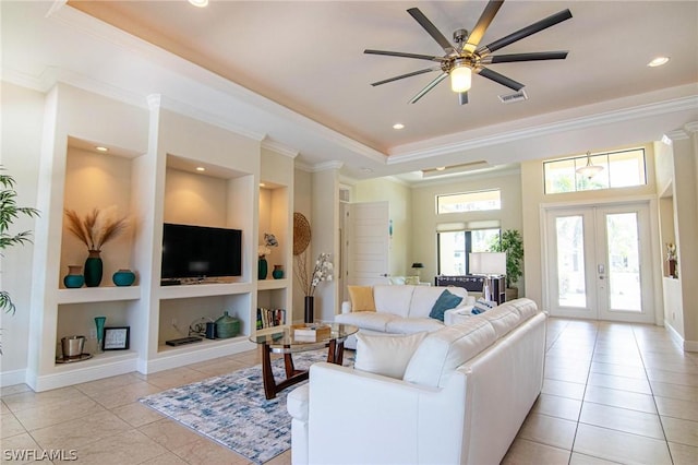 living room with built in shelves, crown molding, french doors, and light tile patterned floors