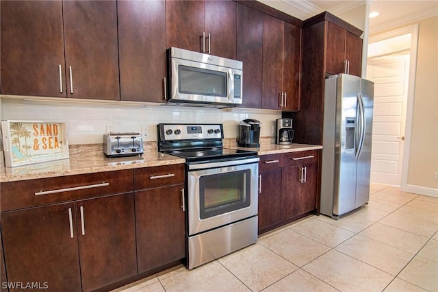 kitchen featuring stainless steel appliances, light stone counters, crown molding, decorative backsplash, and light tile patterned floors