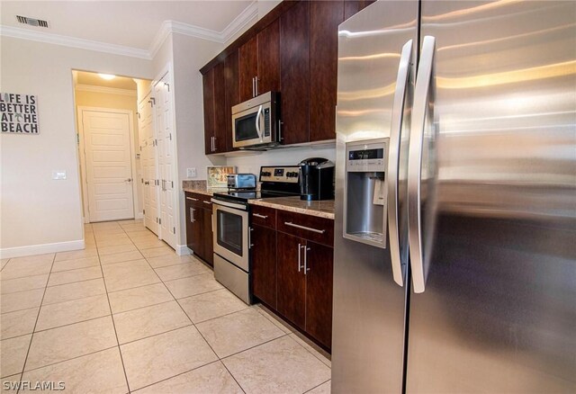 kitchen with light stone countertops, appliances with stainless steel finishes, light tile patterned floors, and crown molding