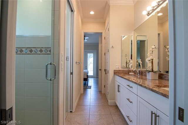 bathroom with tile patterned floors, vanity, a shower with door, and crown molding