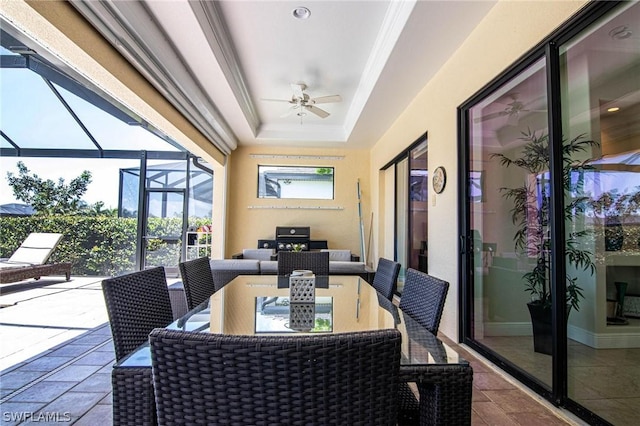 sunroom / solarium with a raised ceiling and ceiling fan