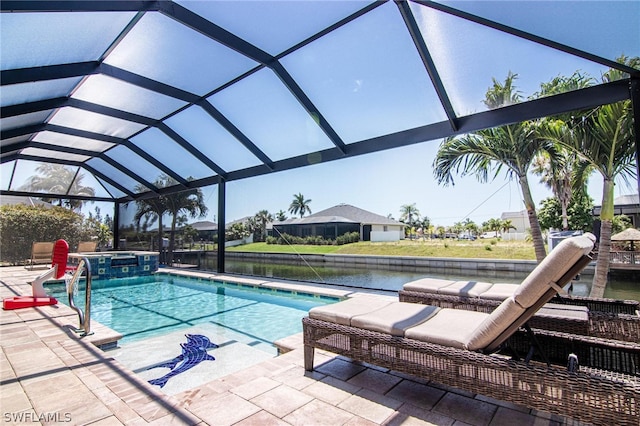 view of swimming pool with glass enclosure, a patio area, a water view, and an in ground hot tub