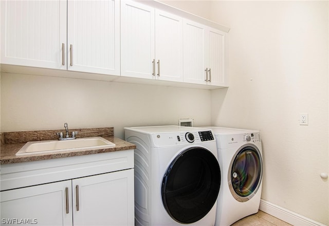 clothes washing area featuring washer and dryer, cabinets, light tile patterned floors, and sink