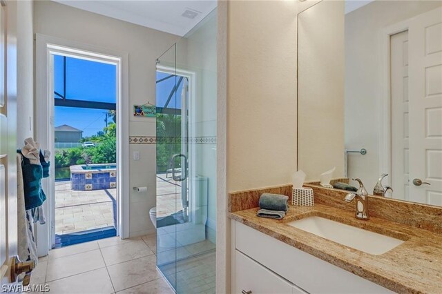 bathroom with tile patterned floors, a shower with door, vanity, and a healthy amount of sunlight