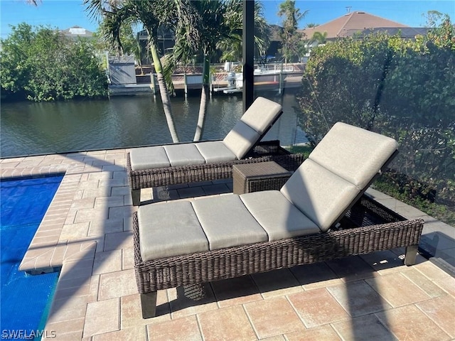 view of dock with a patio area, a water view, and a swimming pool