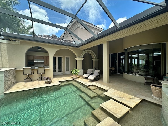 view of swimming pool featuring a patio, french doors, a lanai, and exterior bar