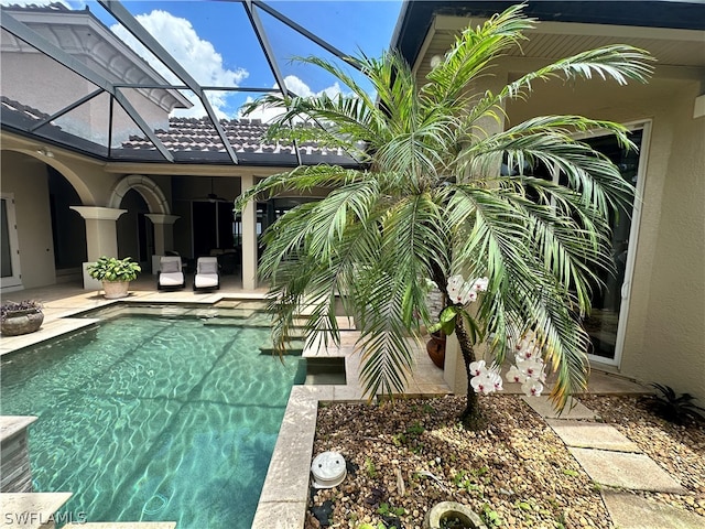 view of swimming pool with a lanai and a patio area