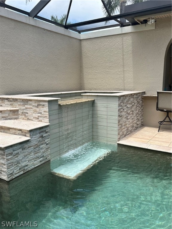 view of pool featuring glass enclosure