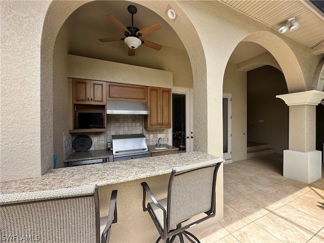 kitchen with backsplash, ceiling fan, light tile flooring, electric stove, and a breakfast bar