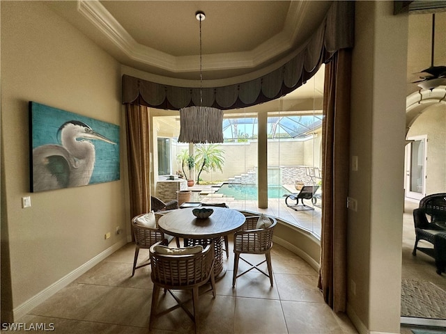 tiled dining space featuring a raised ceiling