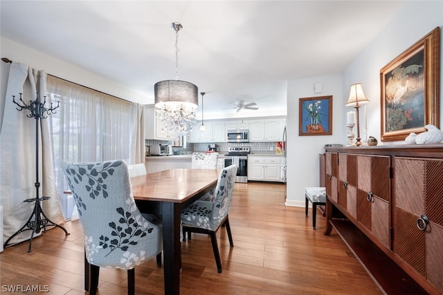 dining room featuring light wood-type flooring and a chandelier