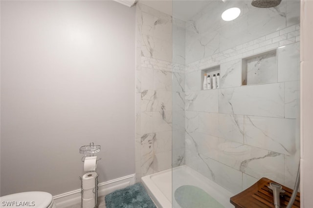 bathroom featuring toilet and a tile shower