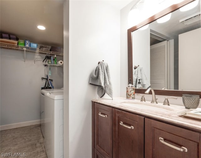 bathroom with independent washer and dryer and vanity