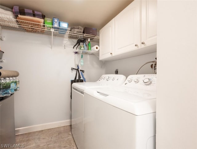 washroom featuring electric dryer hookup, washer and dryer, and cabinets