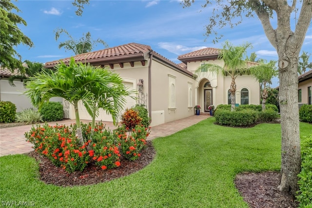 mediterranean / spanish-style house featuring a garage and a front yard